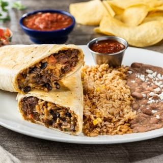 The Big Bordurrito: A HUGE serving of fajita chicken or steak wrapped in a seared flour tortilla with Mexican rice, mixed cheese, black beans, caramelized onion & peppers, pico de gallo and Smoky Queso.