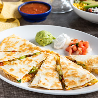 Veggie Quesadilla: Zucchini, squash & bell peppers and roasted red chile tomatillo salsa. Served with fresh guacamole, sour cream and pico de gallo.